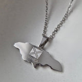 Silver necklace with a pendant shaped like Jamaica on a light gray background