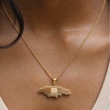 Gold necklace with a pendant worn by a person