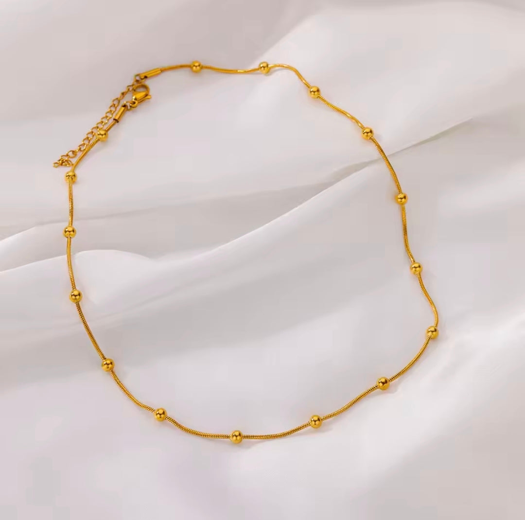 Gold necklace on a white fabric background