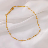 Gold necklace on a white fabric background