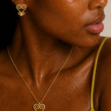 Close-up of a person wearing a gold earring and necklace with 'isura' branding.