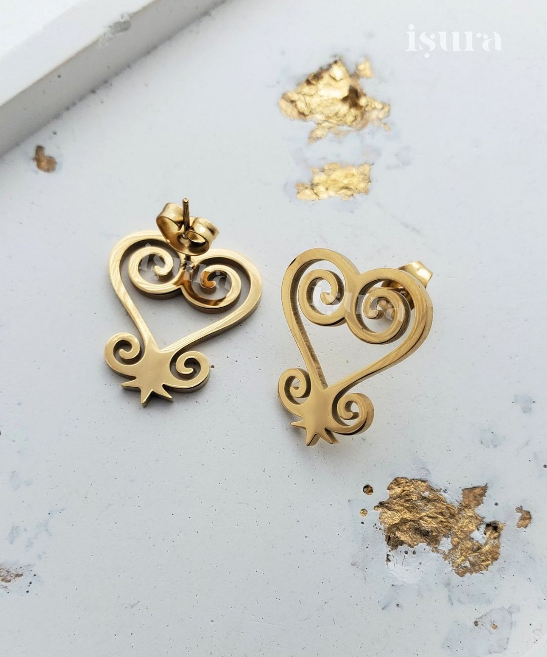Gold heart-shaped earrings on a light background