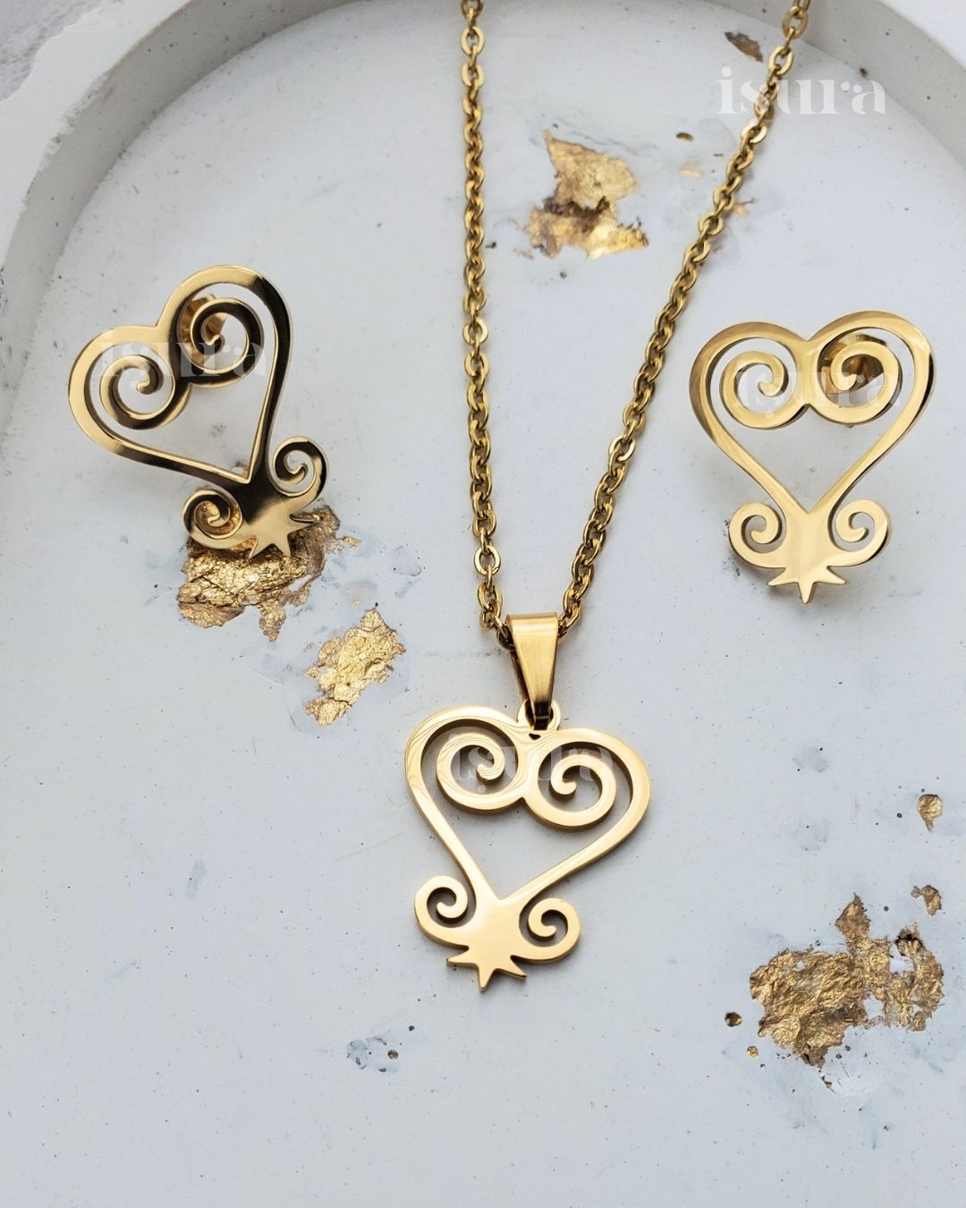 Gold heart-shaped necklace and earrings on a light gray background