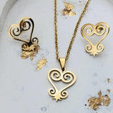 Gold heart-shaped necklace and earrings on a light gray background