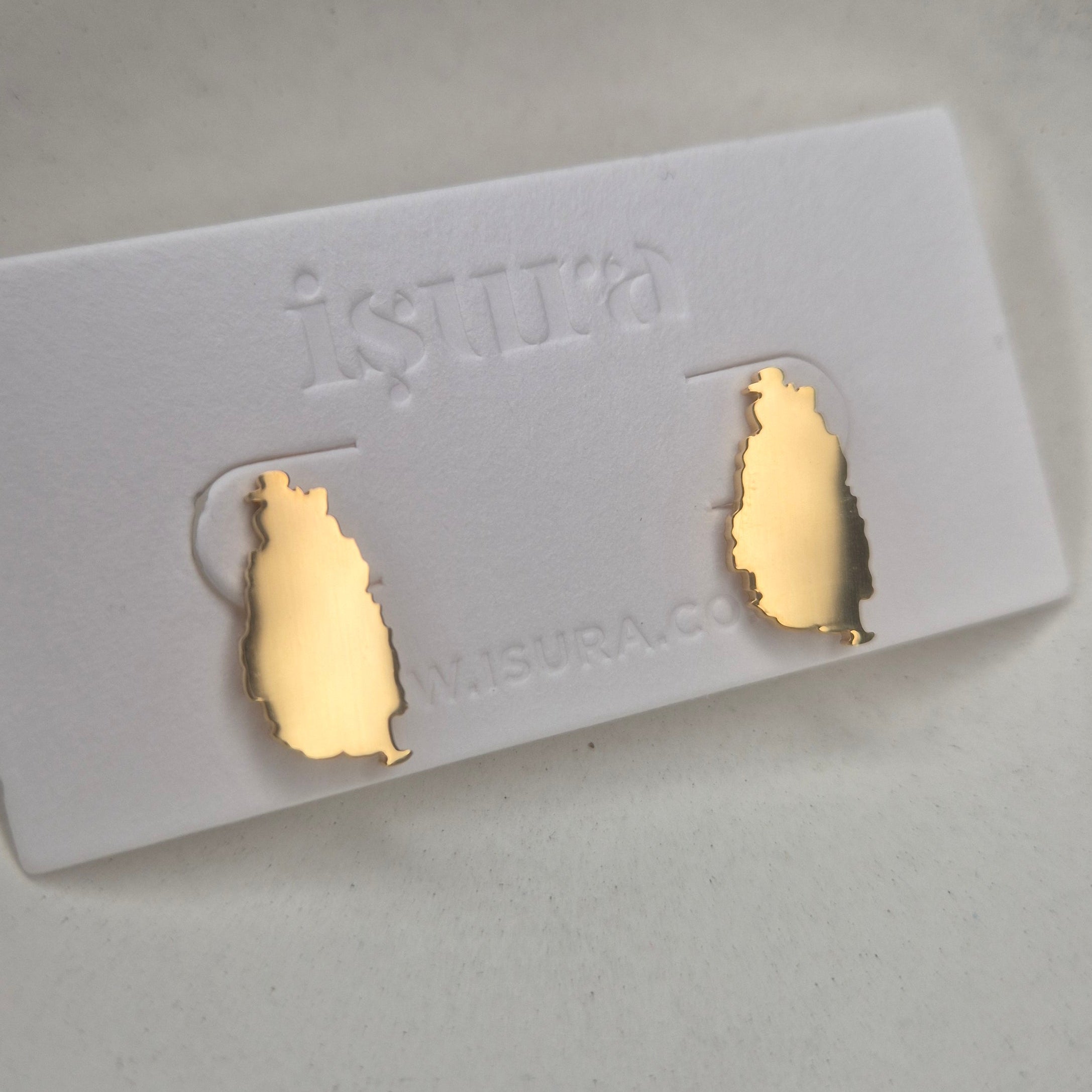 Gold earrings on a card with 'Isura' text, on a white background